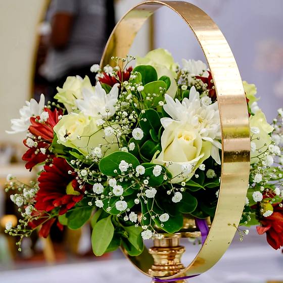 Gold hoop centrepiece filled with white and red roses on a reception table